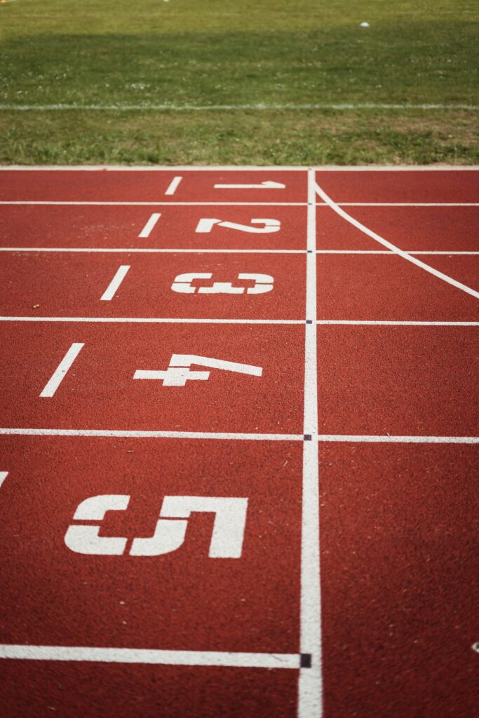 Close-up view of a red running track with numbered starting lanes, perfect for athletic themes.